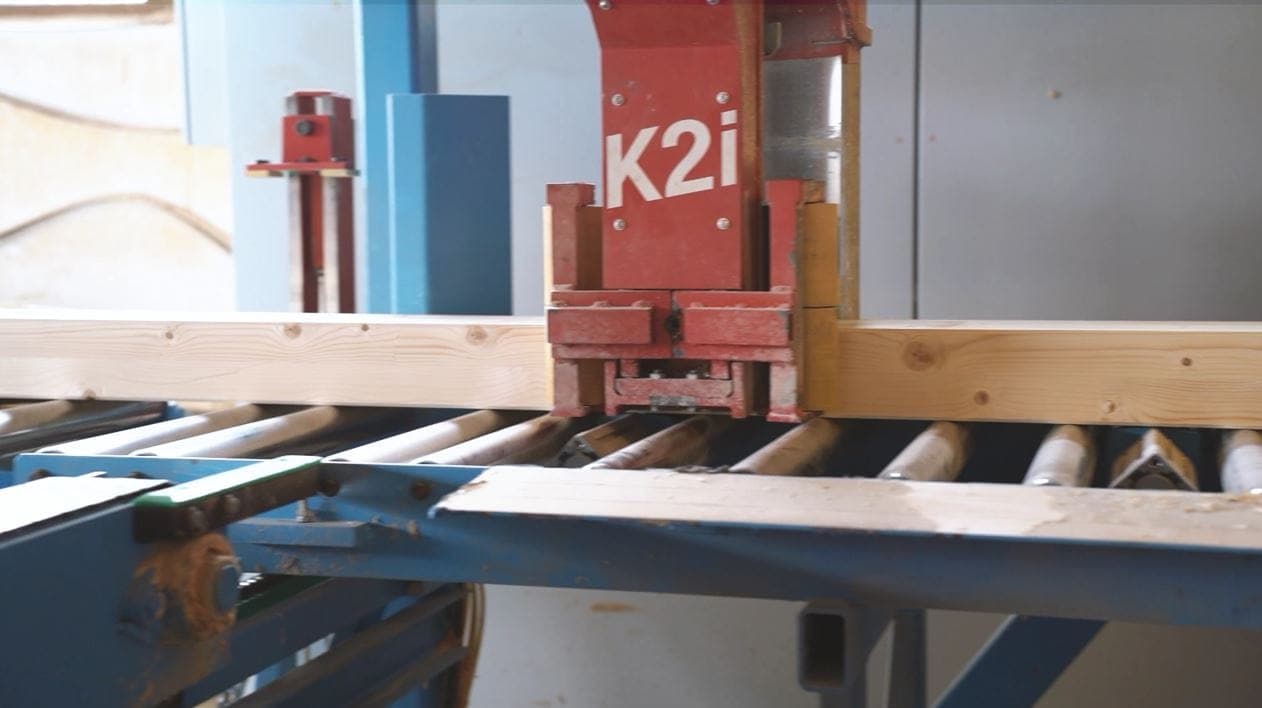 Le centre de taille à commande numérique Hundegger K2i usine une poutre de charpente dans notre atelier